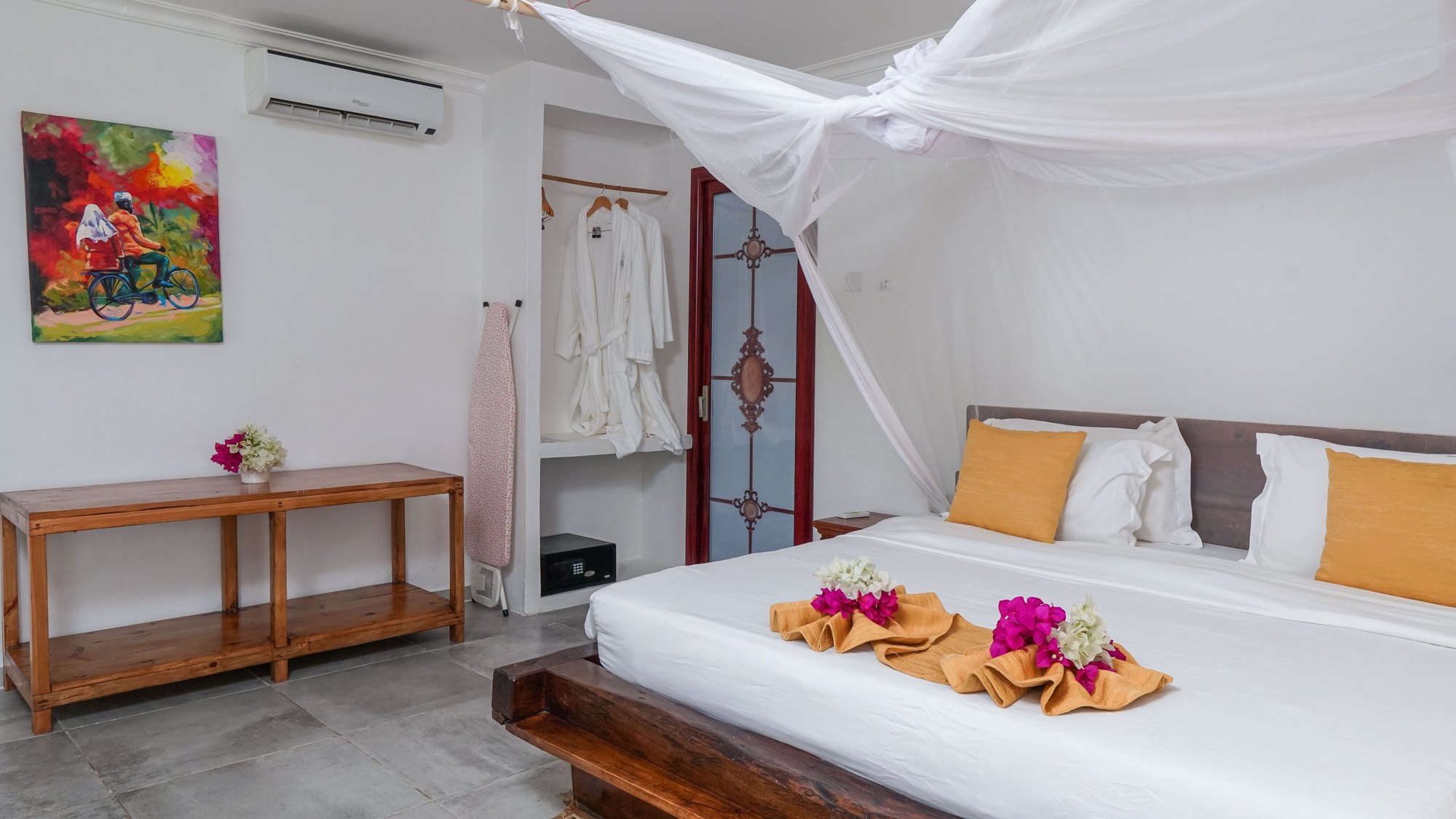 Suite interior with a canopy bed, Swahili artwork and light pouring in