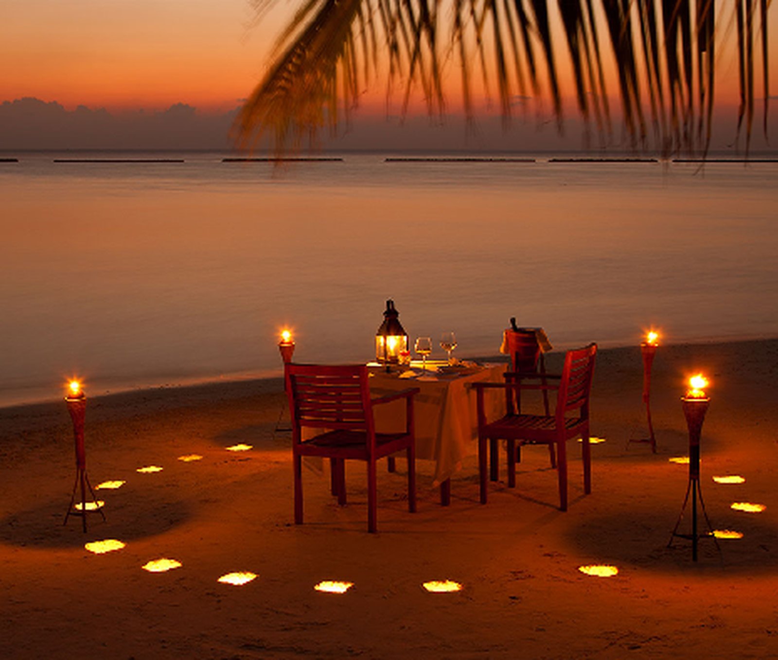 A private candle-lit dinner on the beach as the sun sets over the Indian Ocean