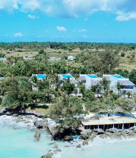 The resort and its private beach seen from the turquoise sea