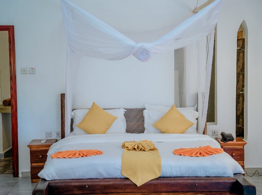 Ocean Sea View suite with a canopy bed and warm Swahili accents
